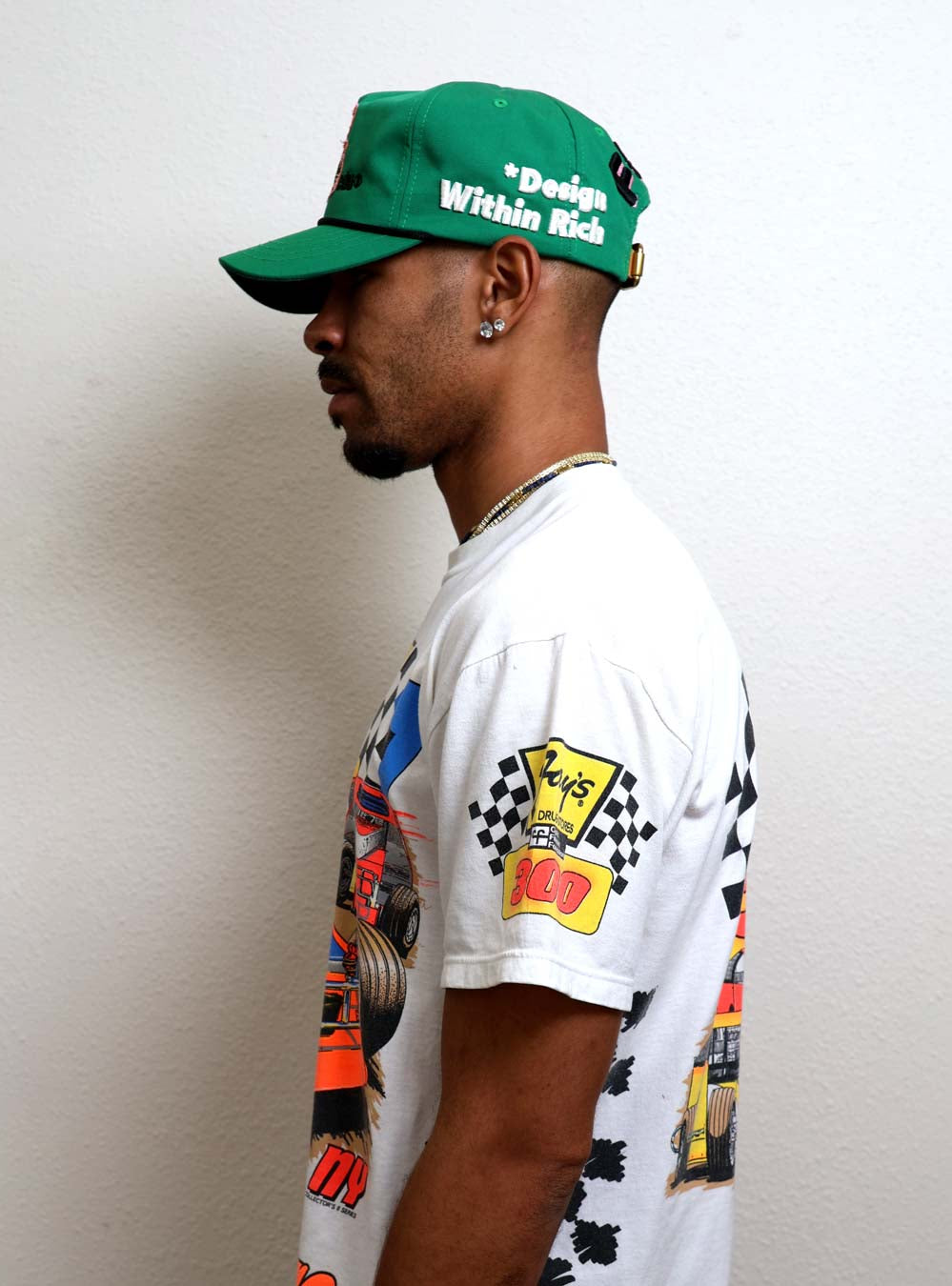 Man in green cap and graphic t-shirt.