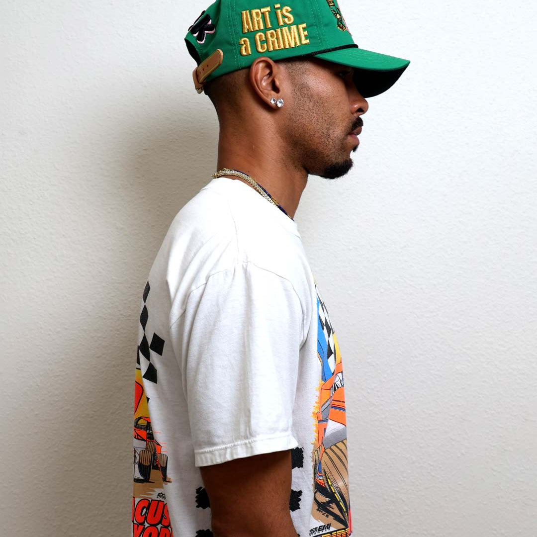 Profile of a person wearing a green cap and graphic tee.