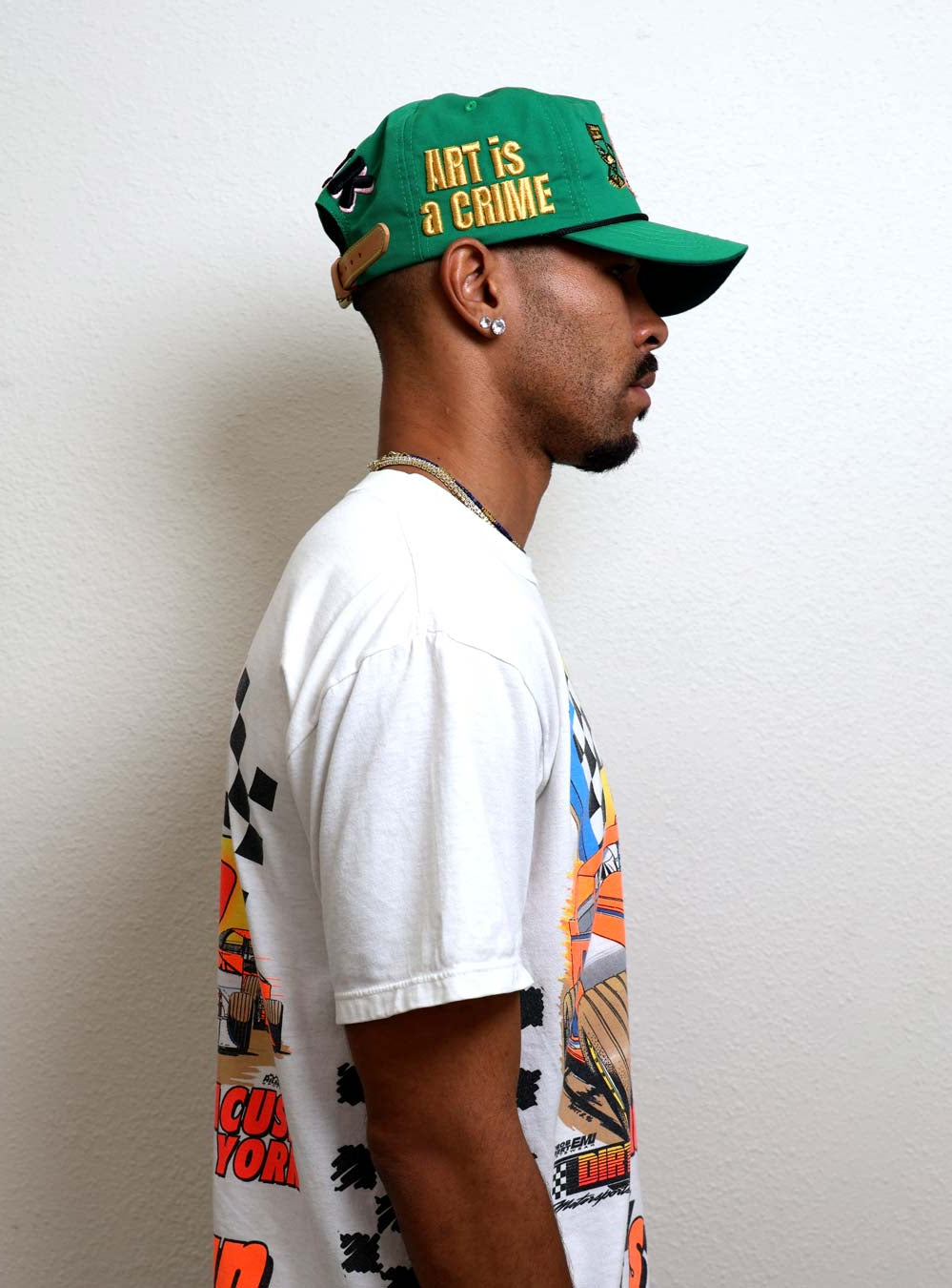 Profile of a person wearing a green cap and graphic tee.