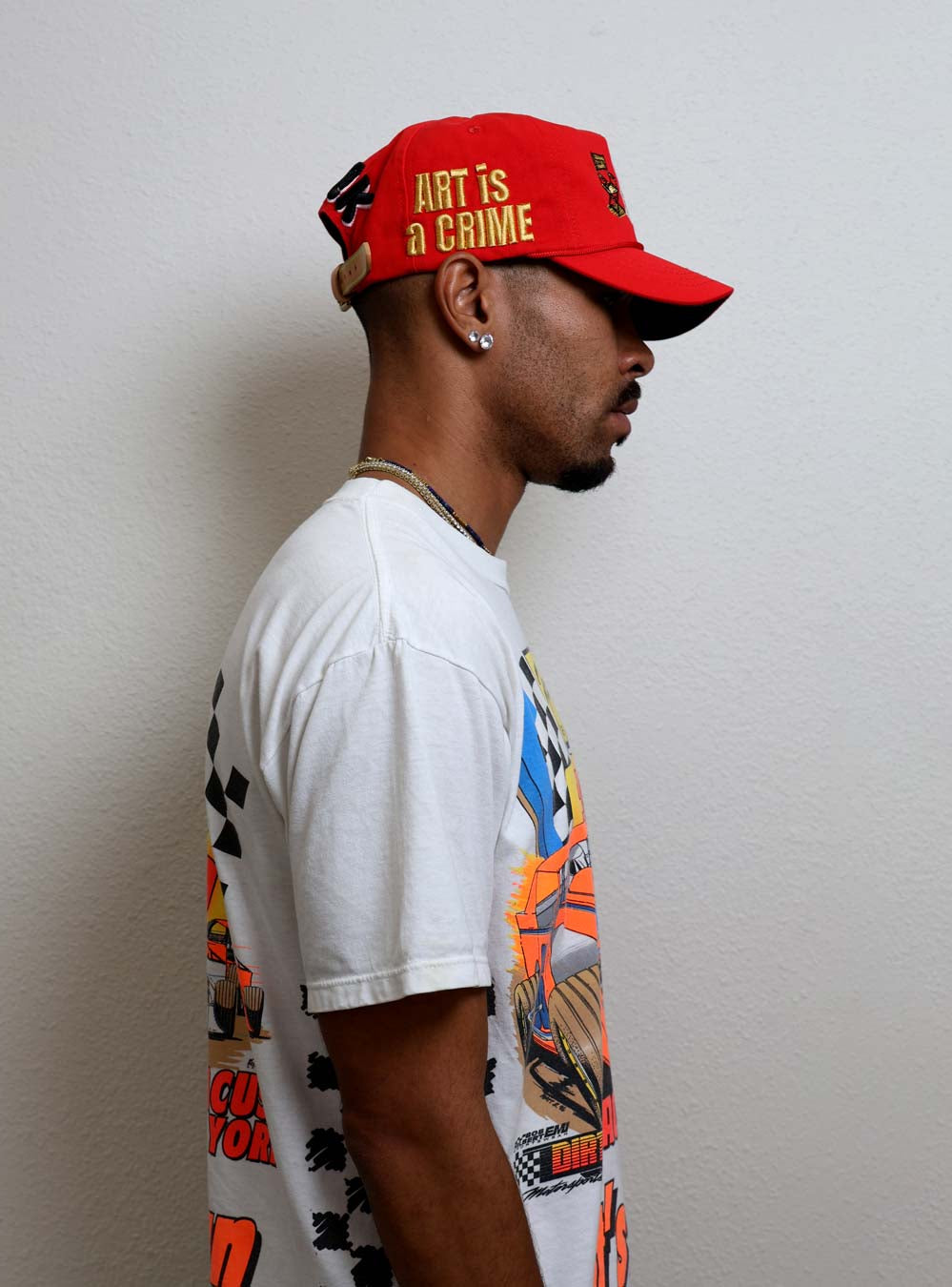 Man wearing graphic t-shirt and red cap.