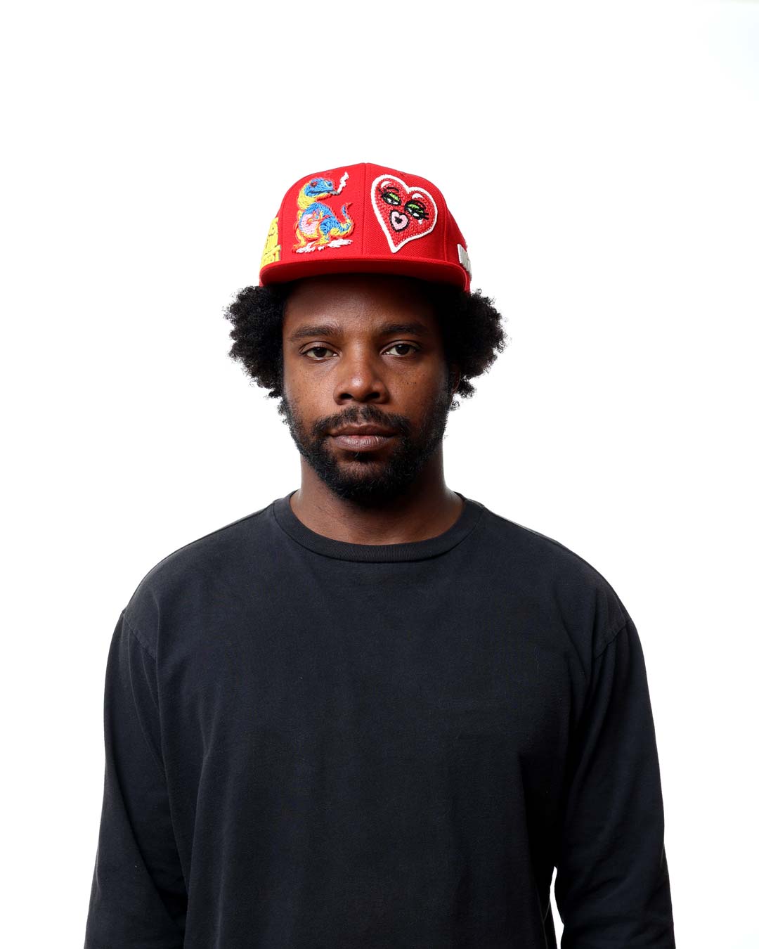 Man wearing a red cap with cartoon characters on a white background