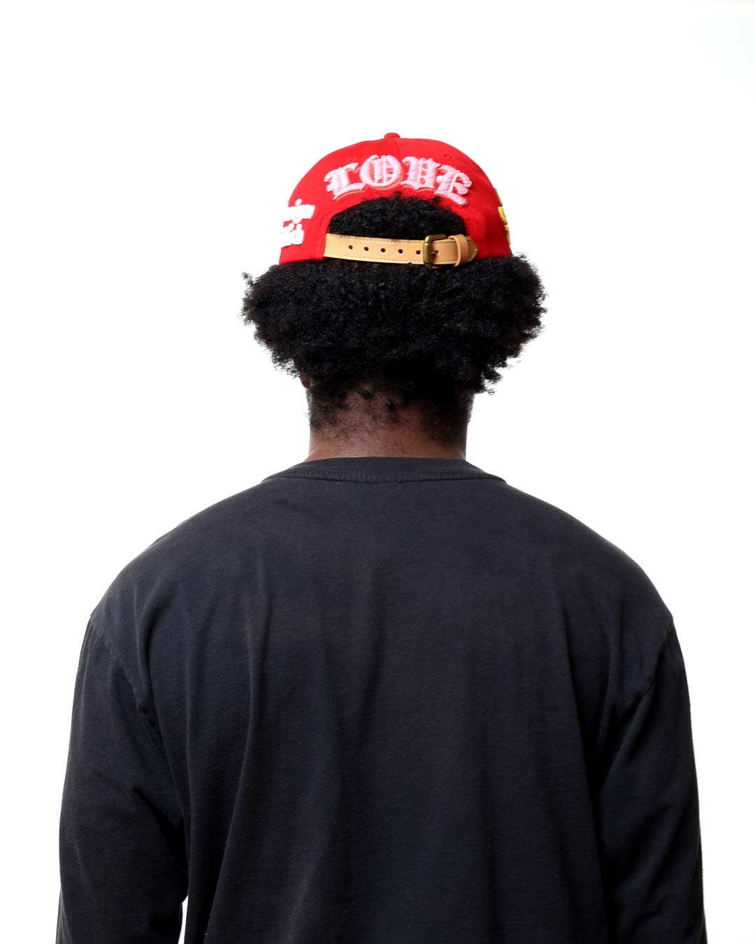 Person wearing a red cap with 'LOVE' on it, facing away from the camera.
