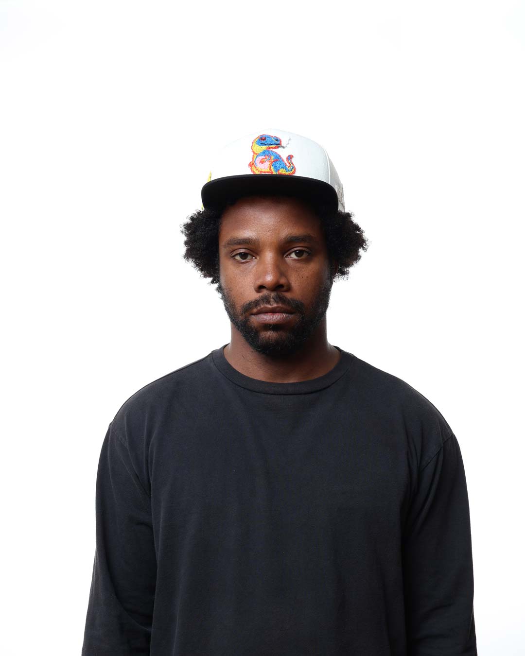 Man wearing a black shirt and colorful cap on a white background