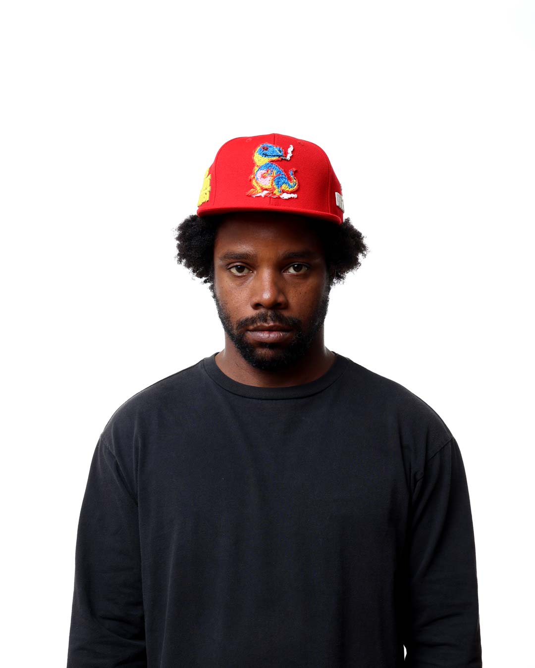 Person wearing a red cap with a colorful design on a white background