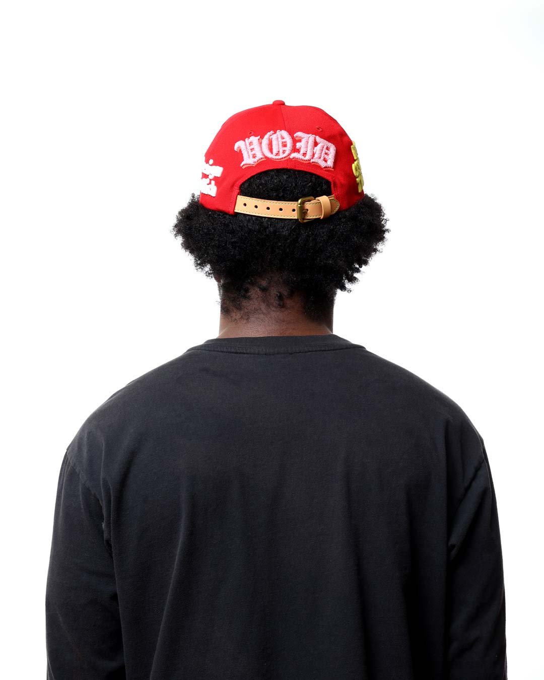 Person wearing a red cap with white text on a white background