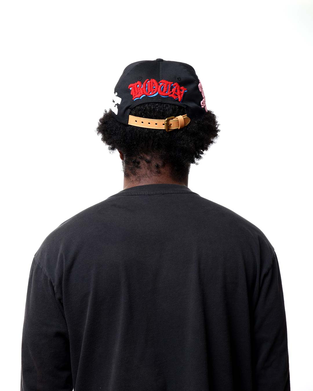 Person wearing a black cap with red text on a white background
