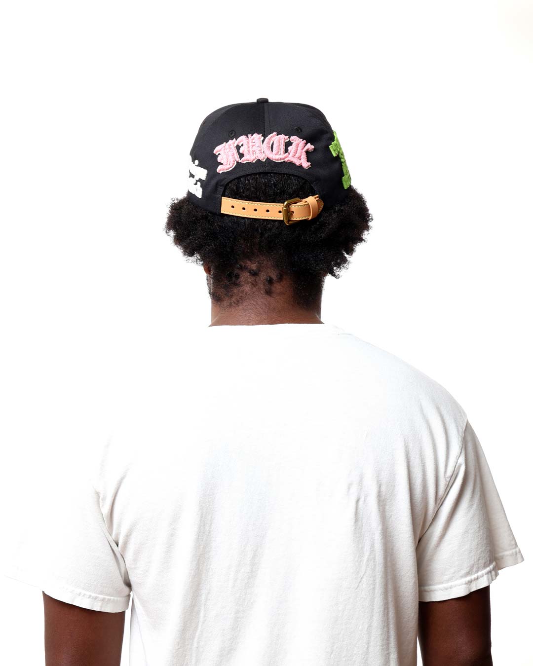 Person wearing a black cap with pink text on a white background