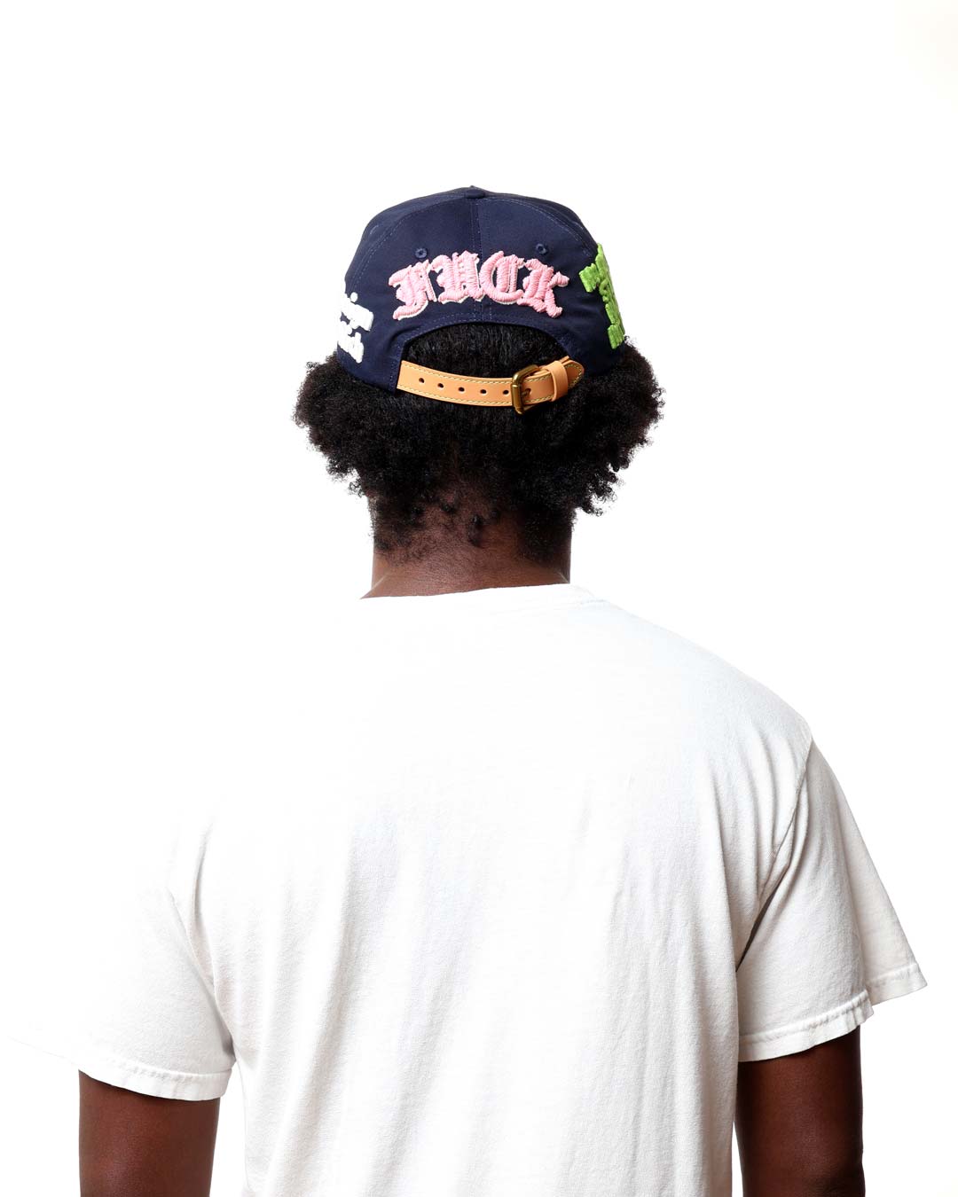 Person wearing a navy blue cap with pink text on a white background