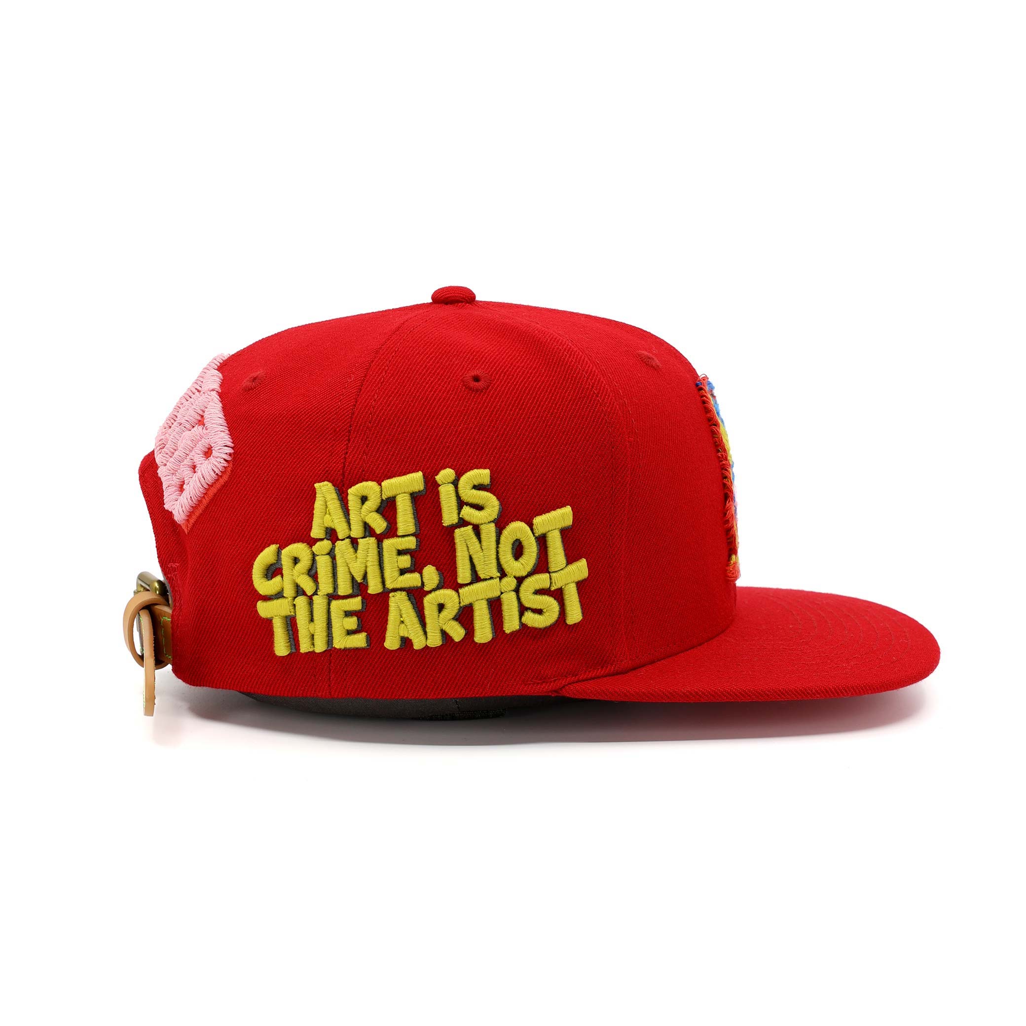 Red cap with yellow text 'Art is Crime, Not the Artist' on a white background
