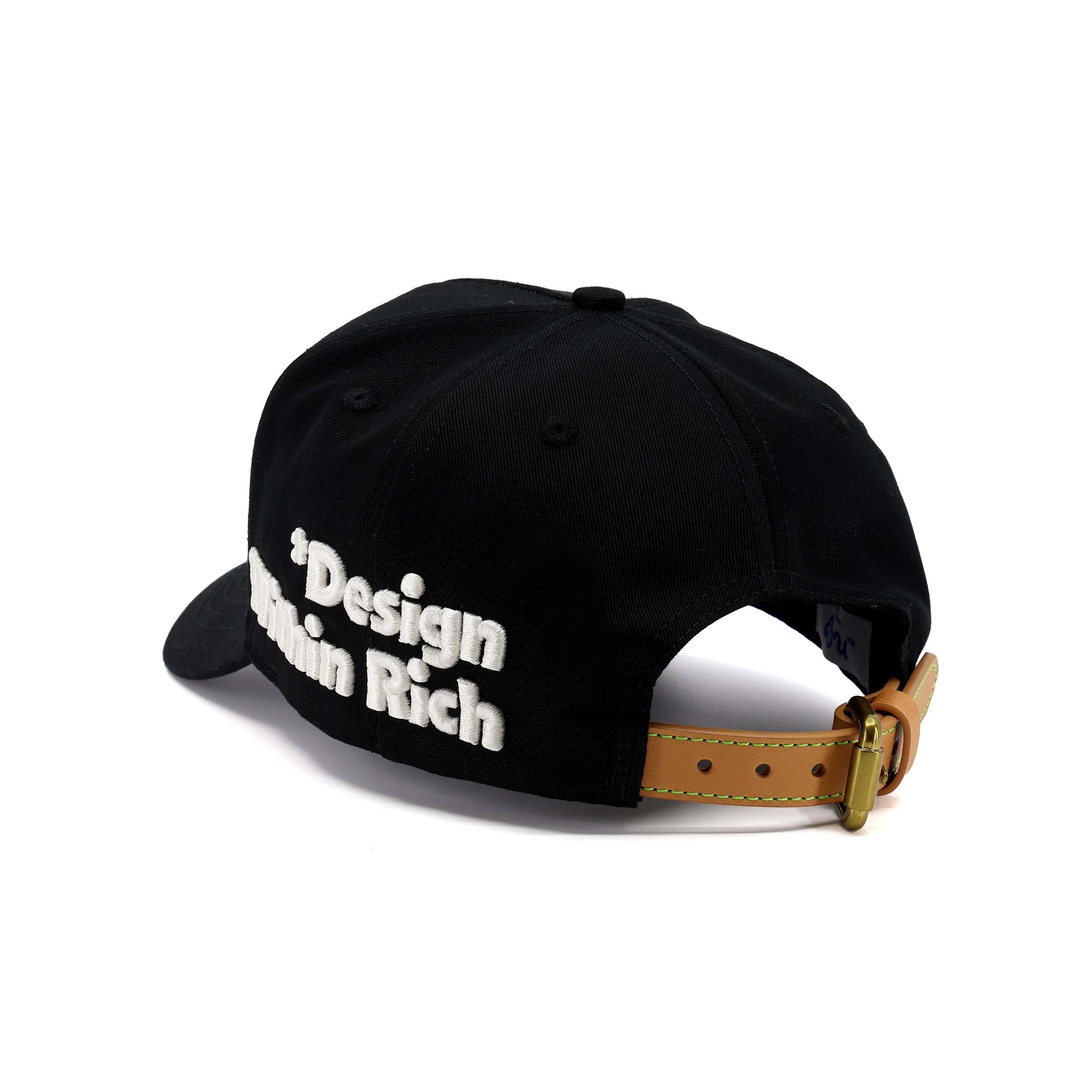 Black cap with 'Design is not a Rich' text on a white background