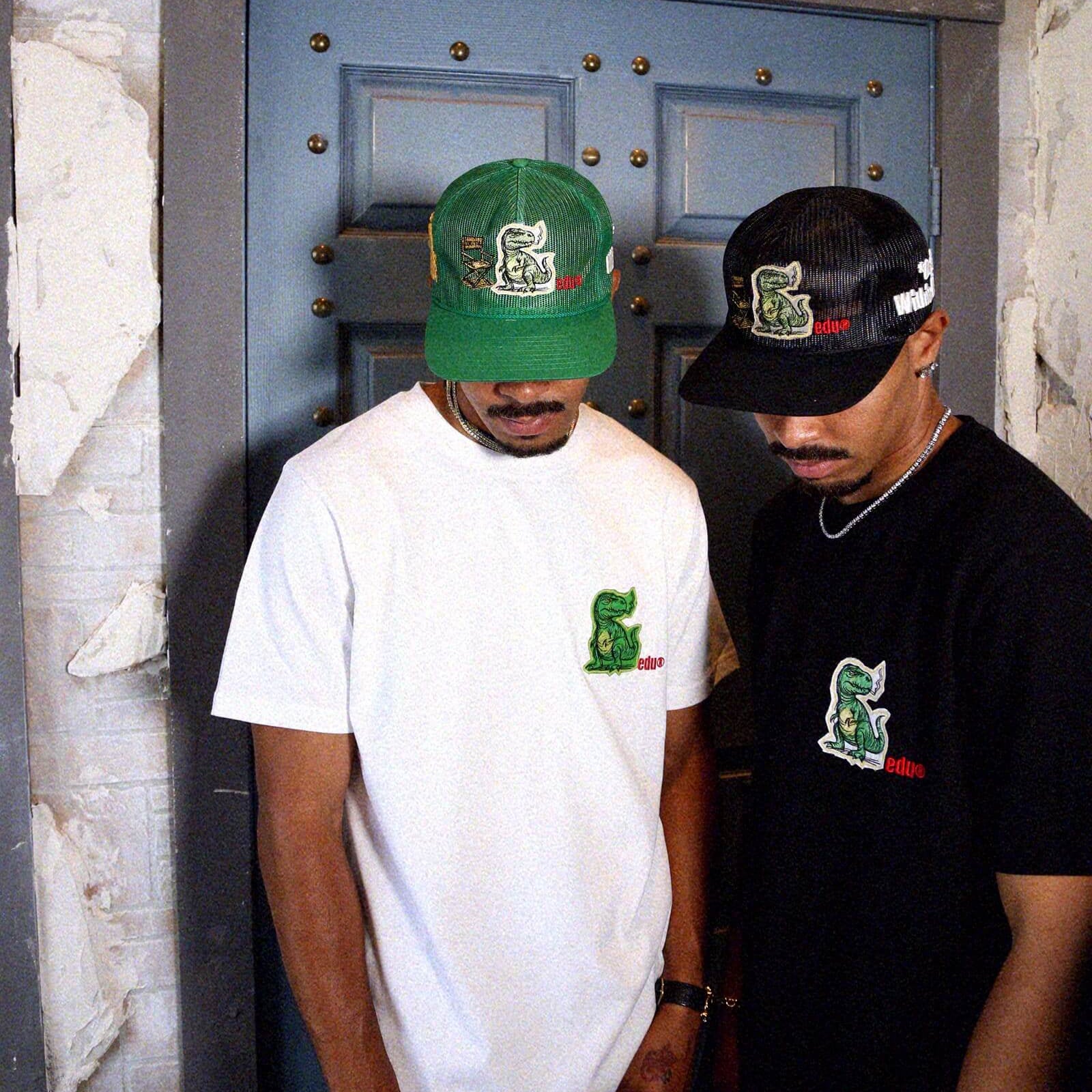 Man in cap and graphic t-shirt, standing sideways.