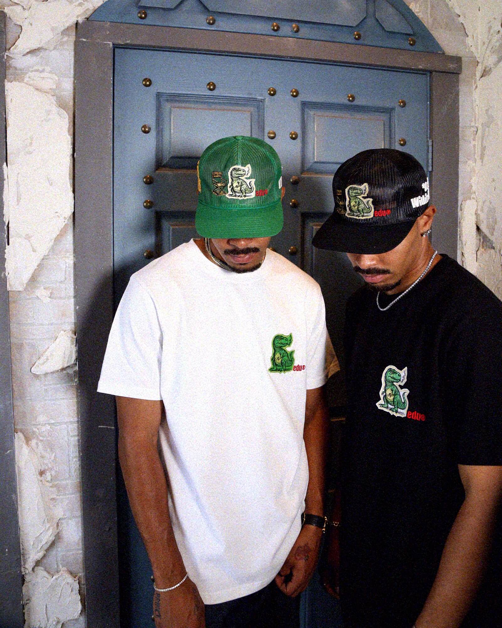 Man in cap and graphic t-shirt, standing sideways.