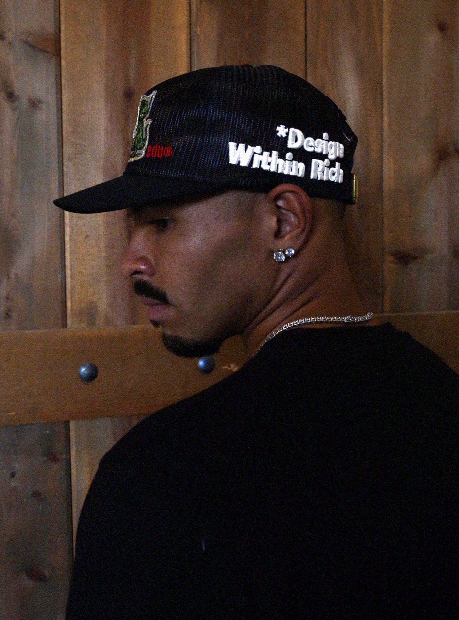 Black mesh cap with embroidered text and strap.