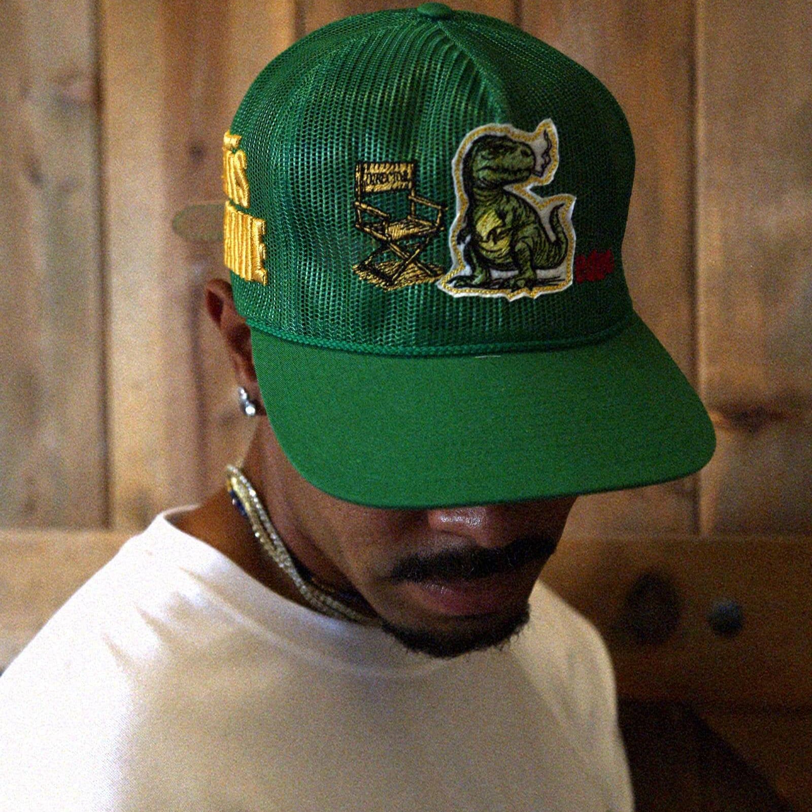 Man in white t-shirt and cap with graphic designs.