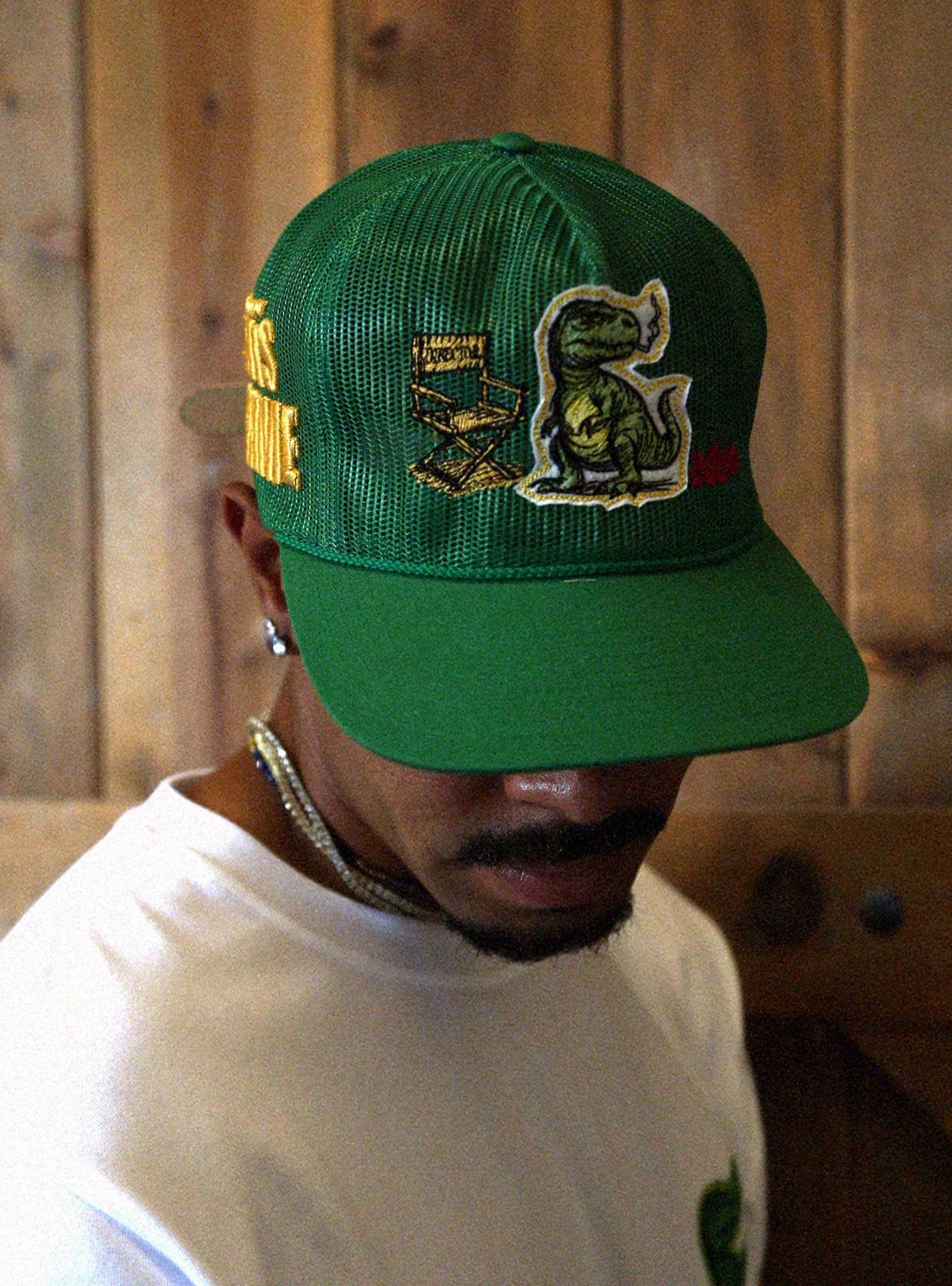 Man in white t-shirt and cap with graphic designs.
