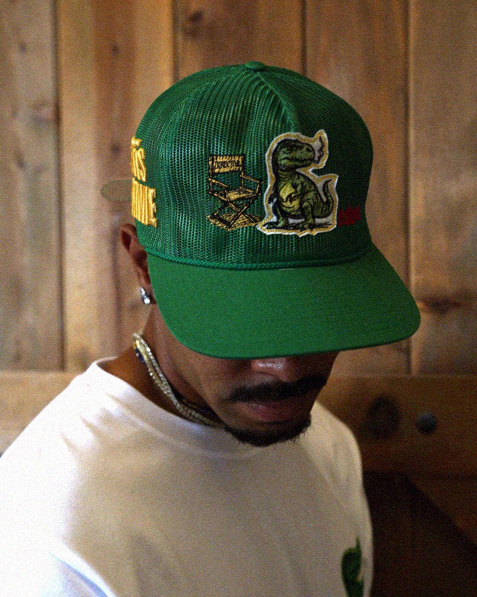 Man in white t-shirt and cap with graphic designs.