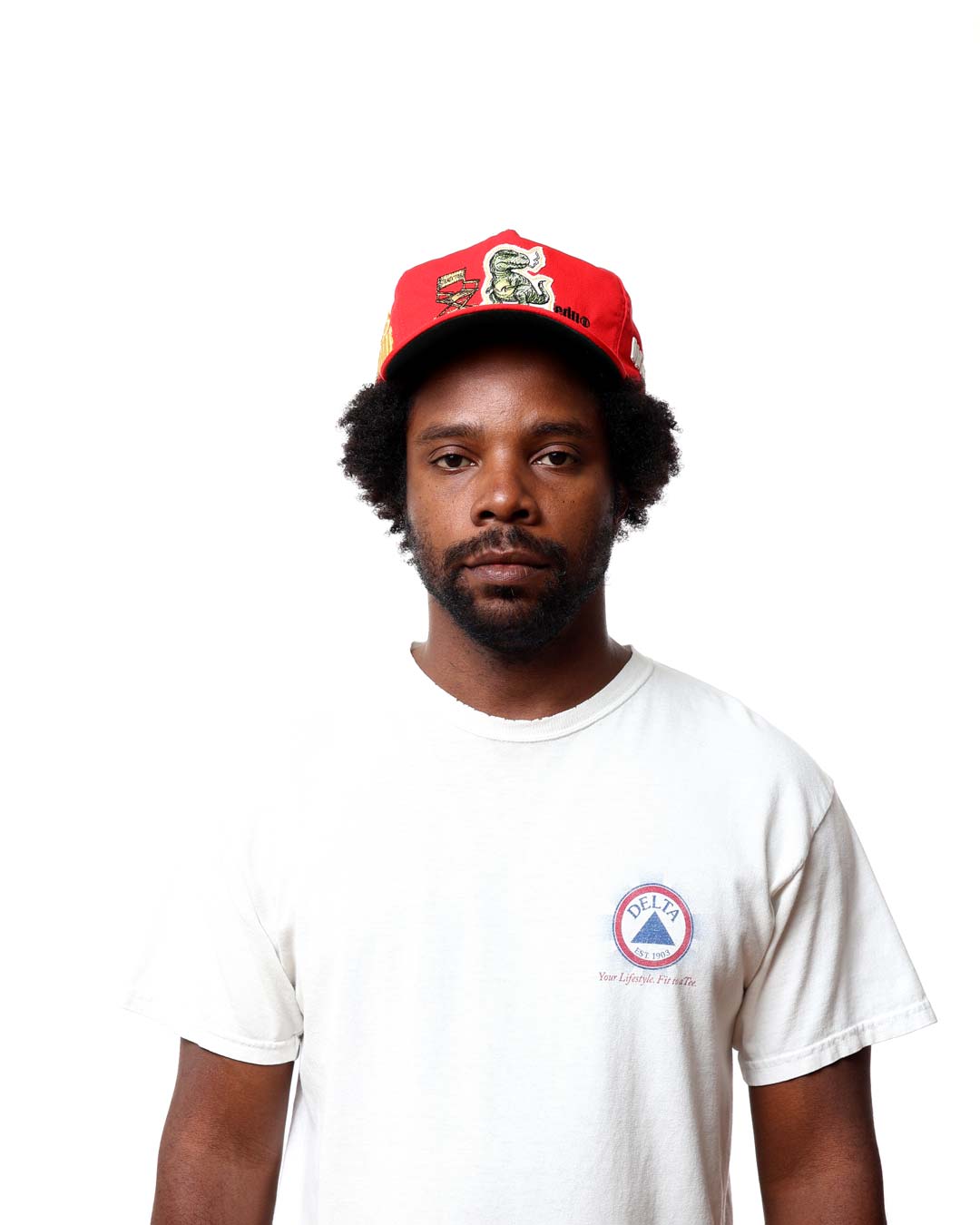 Man wearing a red cap and white t-shirt with a logo on a white background