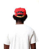 Person wearing a red cap with black text on a white background