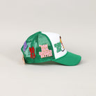 Green and white trucker hat with embroidered patches.