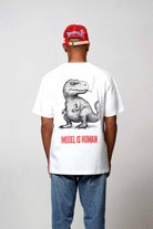 Man wearing dinosaur graphic t-shirt and red cap.
