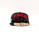 Black cap with red embroidered text, adjustable strap.