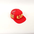 Red cap with yellow embroidered text.