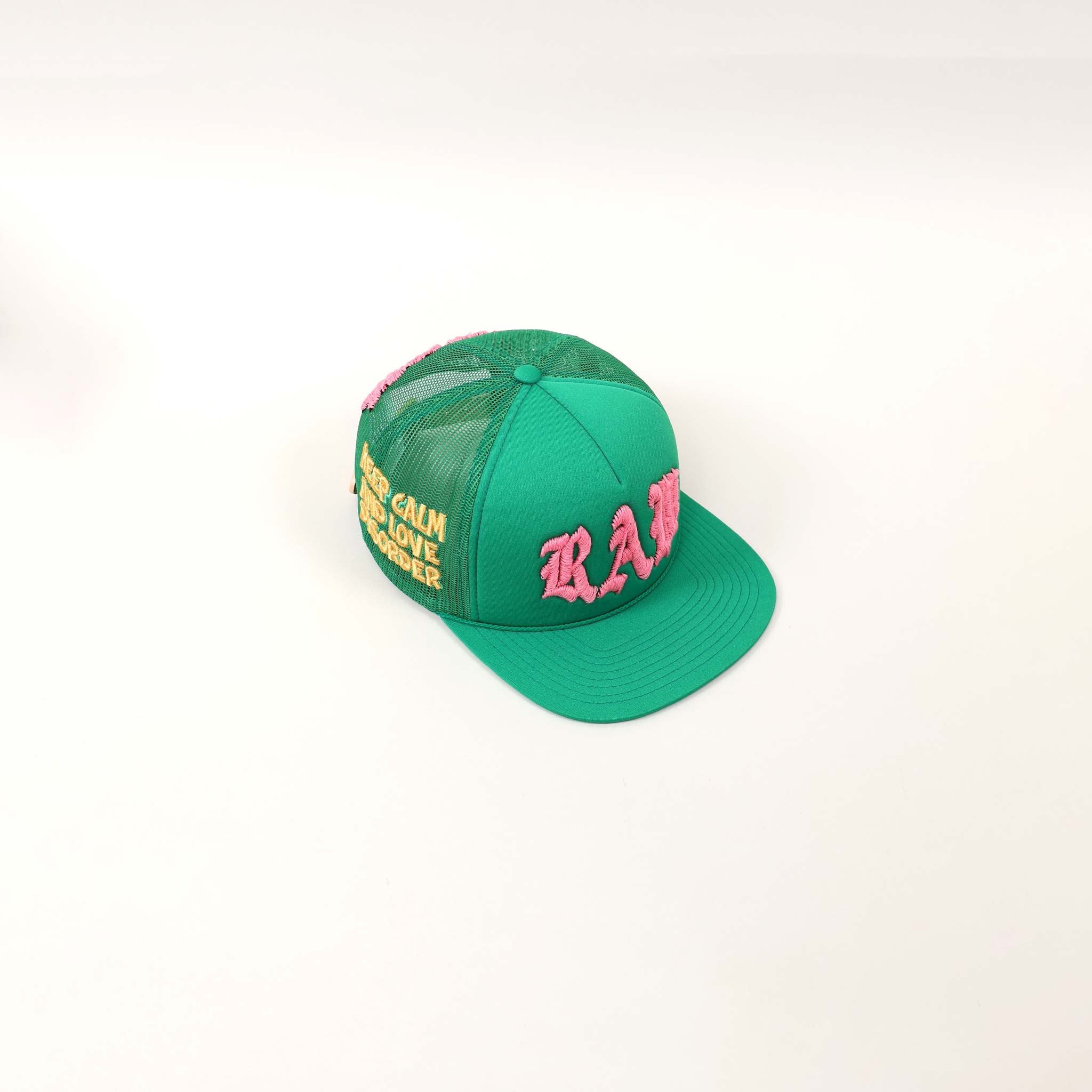 Green cap with pink and yellow embroidery.