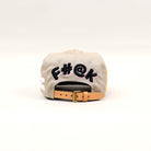 Back view of a beige cap with embroidered text.