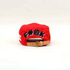 Red cap with embroidered text on the back.