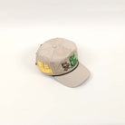 Beige cap with embroidered designs and text.