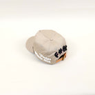 Beige cap with text design on back.