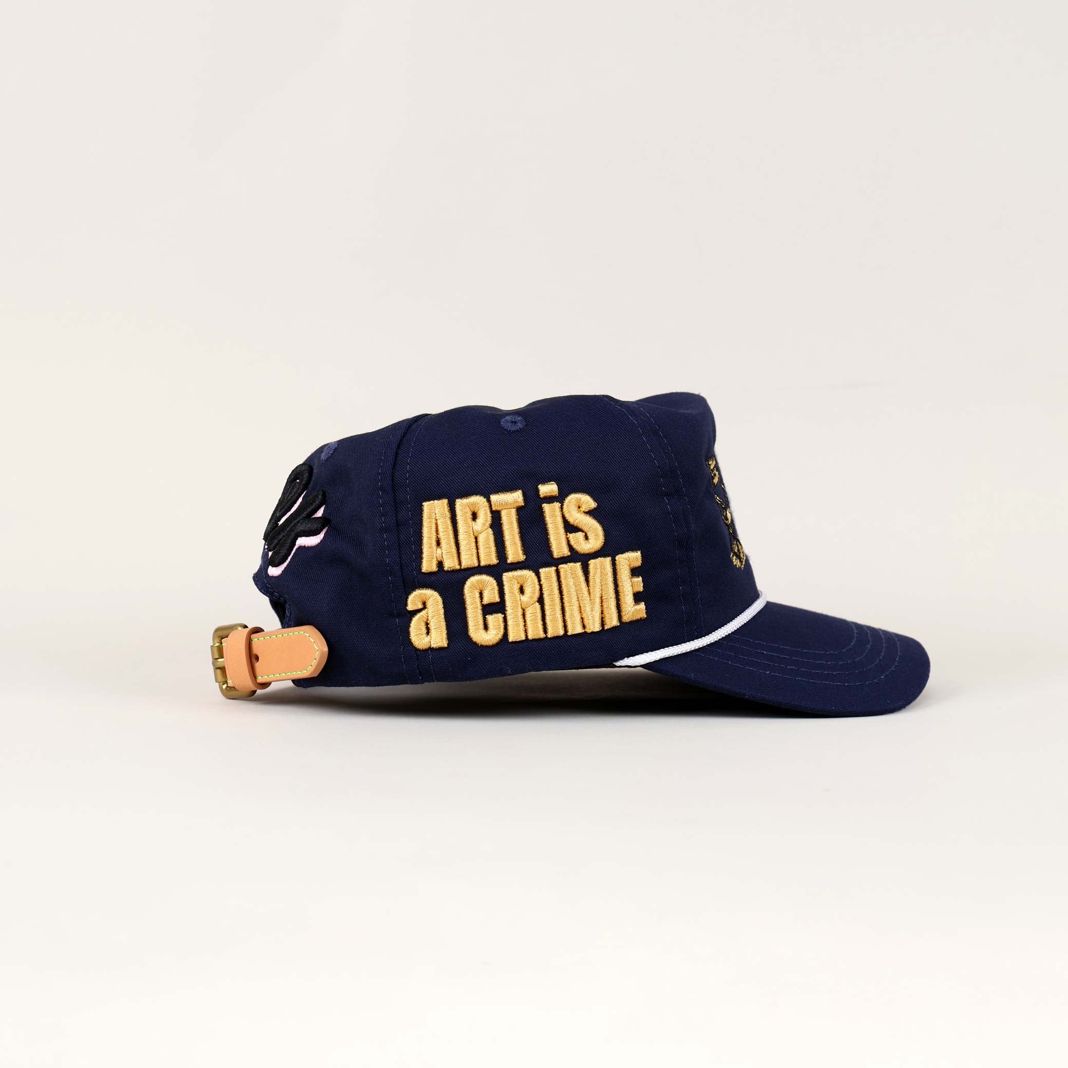 Blue cap with "ART is a CRIME" text.
