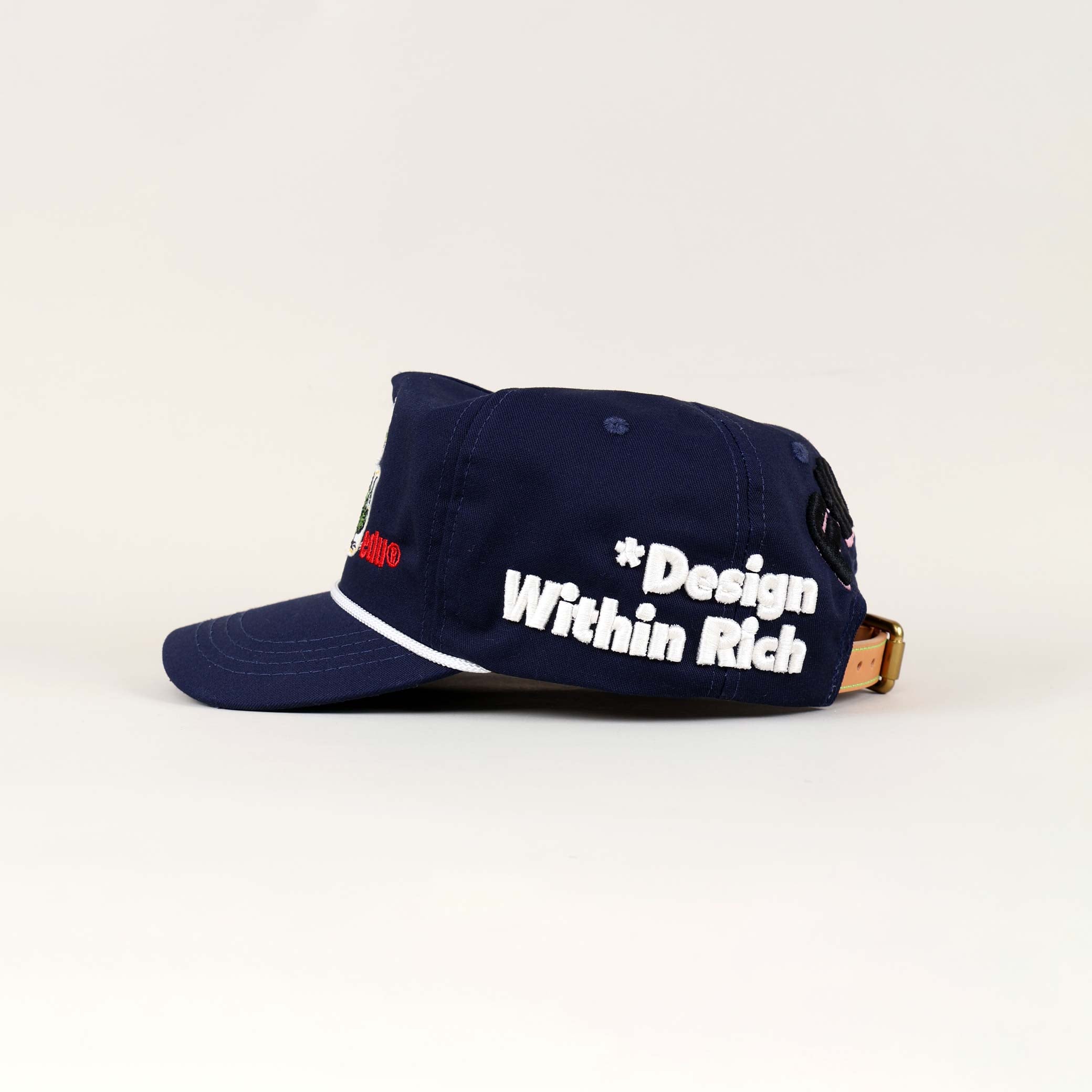 Navy cap with "Design Within Rich" text.