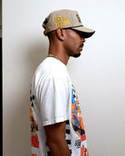 Man in graphic tee and cap, side profile.