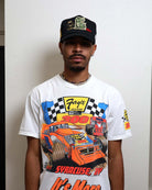 Man wearing a racing-themed shirt and cap.