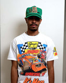 Man wearing graphic t-shirt and green cap.