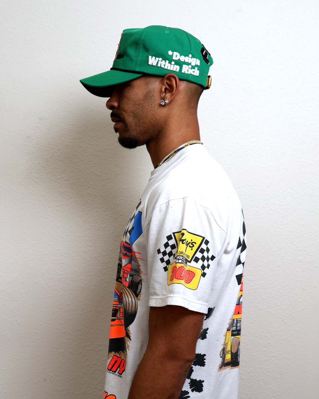 Man in green cap and graphic t-shirt.