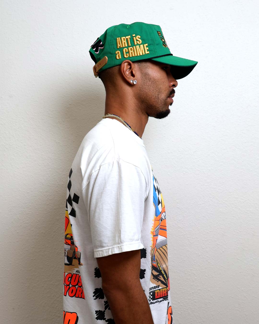 Profile of a person wearing a green cap and graphic tee.