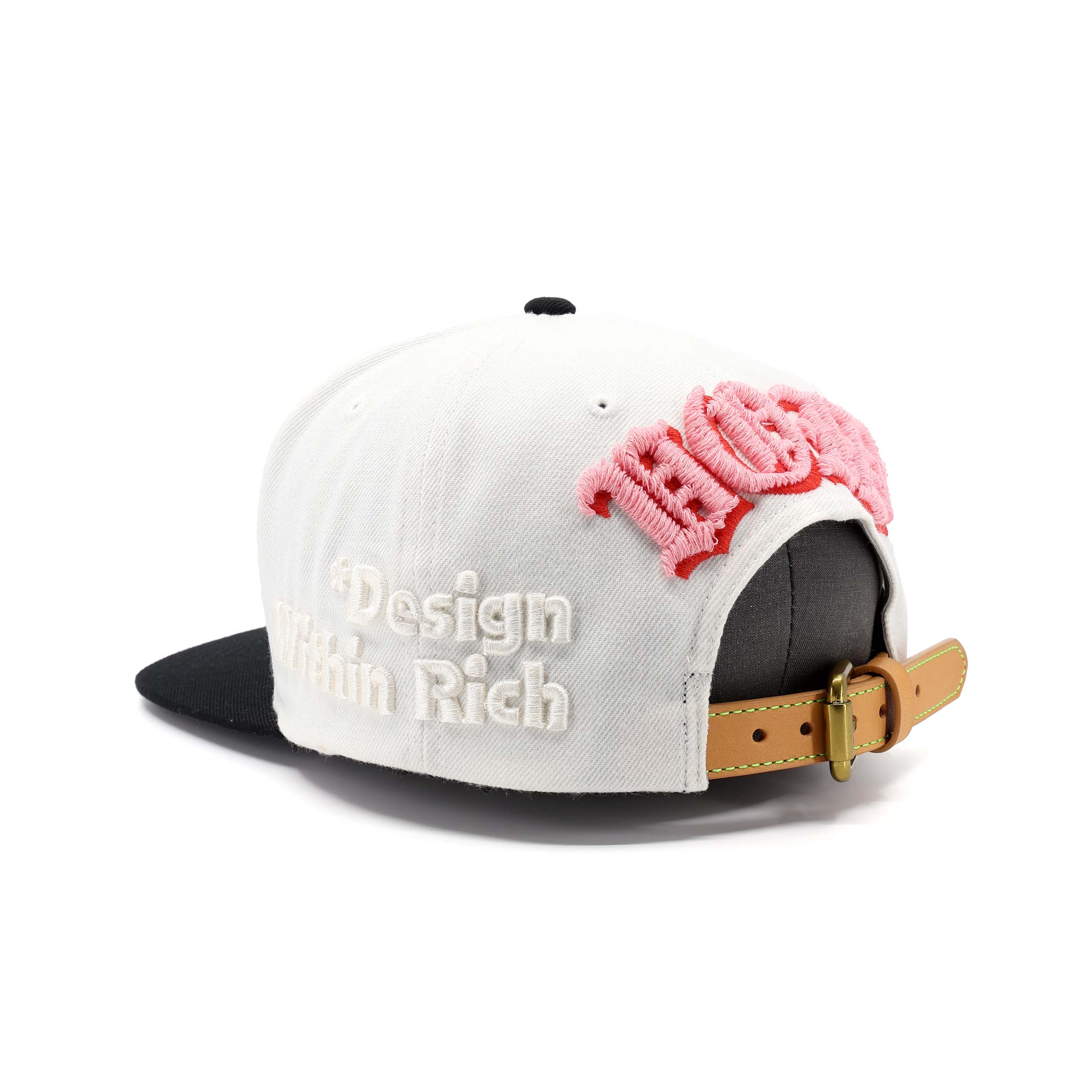 White cap with pink floral design and 'Design Rich' text on a white background