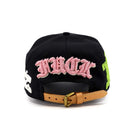 Black cap with pink text and a brown leather strap on a white background