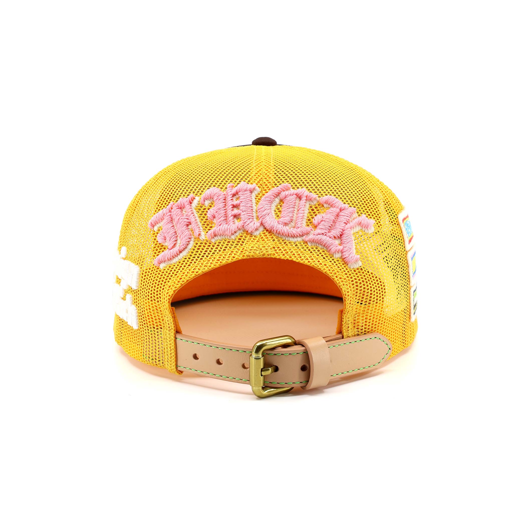 Yellow cap with pink text and a gold buckle on a white background