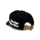Black cap with 'Design is not a Rich' text on a white background