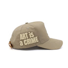 Beige cap with 'Art is a Crime' text on a white background