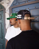 Black and white trucker hat with text on side.